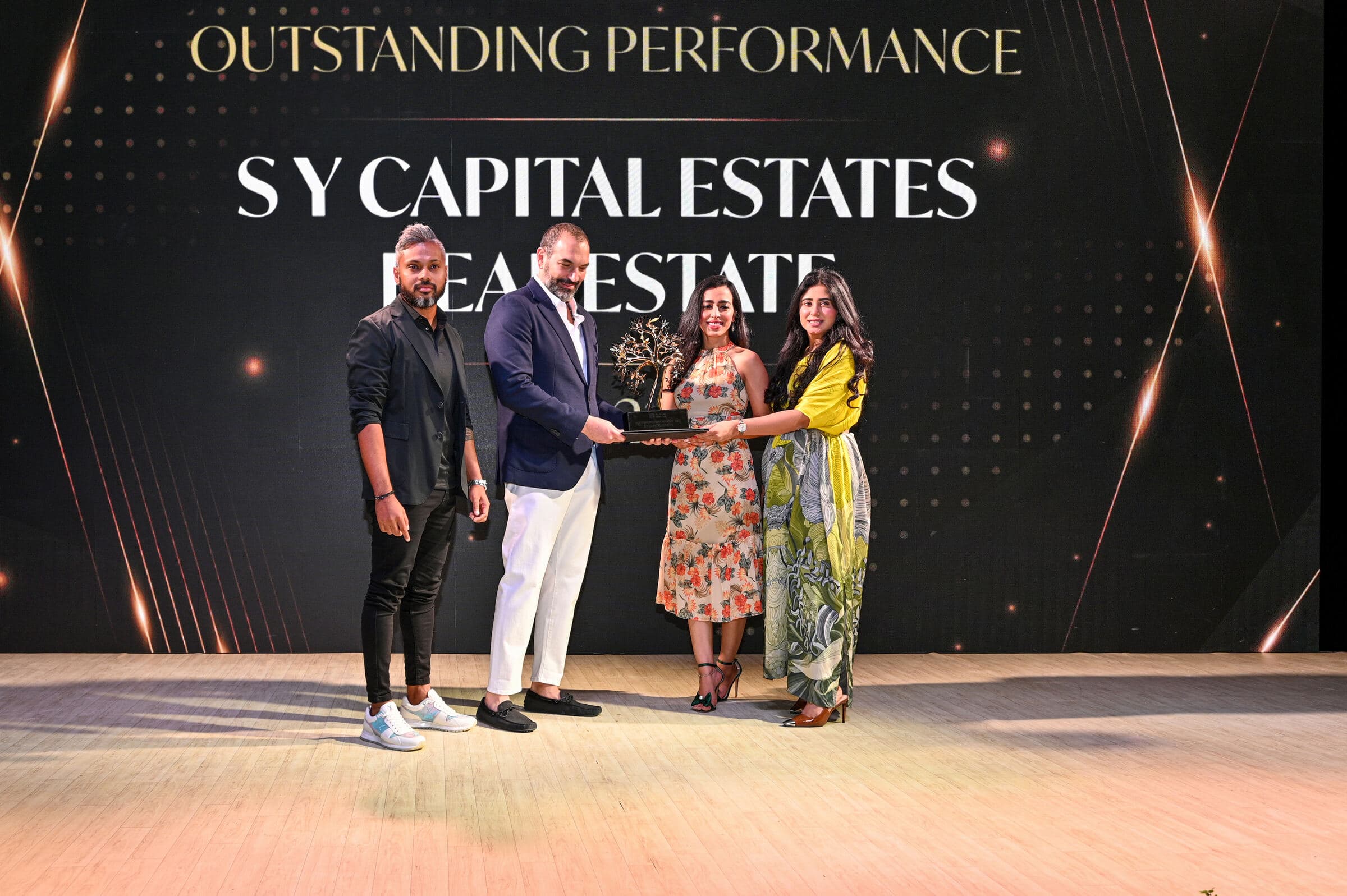 SY Capital Estates receiving the Tilal Al Ghaf Outstanding Performance award on stage